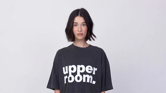 A girl wearing UPPERROOM merch